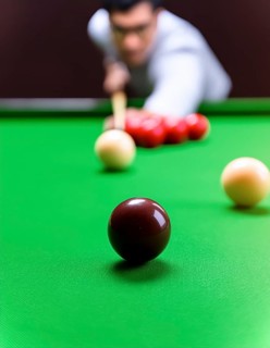 AI generated image showing a billiards table closeup with player and balls