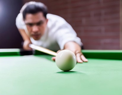 AI generated image showing a billiards table closeup with player and cue ball