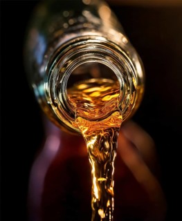 AI-generated close-up image showing a bottle as a clear drink is poured from it, AI generated
