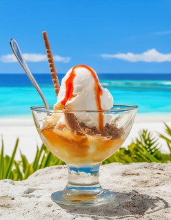 Ice cream sundae with fresh fruits in sunny tropical beach ambiance, AI generated image
