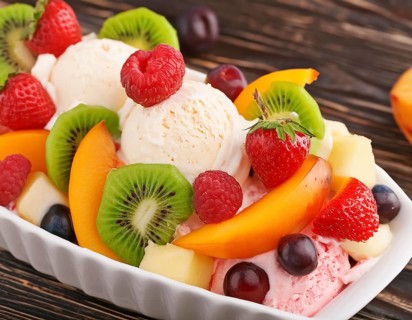 Closeup shot of a ice cream sundae with fresh fruits on wooden ground, AI generated image