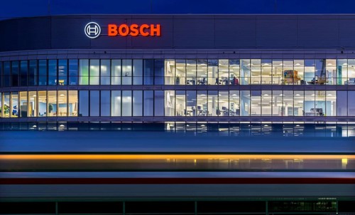 Modern office building of Bosch GmbH in Feuerbach at night with illuminated logo of the automotive