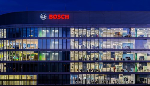 Modern office building of Bosch GmbH in Feuerbach at night with illuminated logo of the automotive