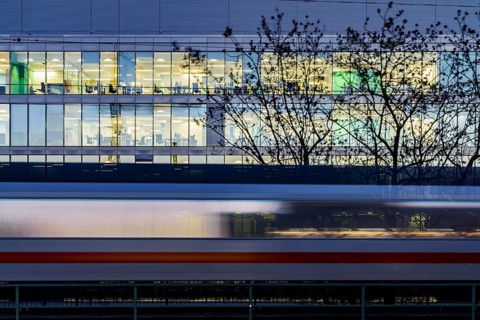 Office building at night. In front of it a passing ICE train of Deutsche Bahn AG. Stuttgart,