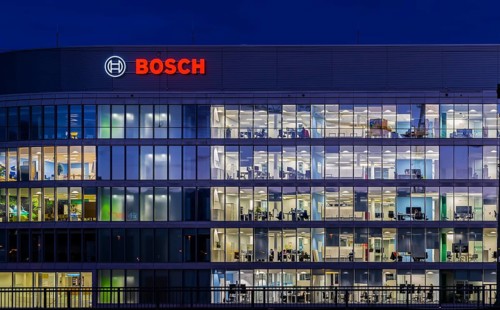 Modern office building of Bosch GmbH in Feuerbach at night with illuminated logo of the automotive