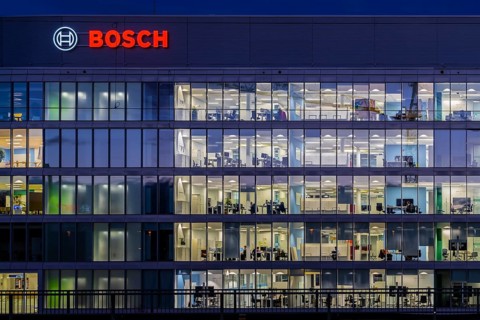 Modern office building of Bosch GmbH in Feuerbach at night with illuminated logo of the automotive