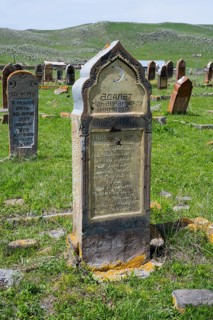 Historic gravestones on a grassy cemetery with hills in the background, old cemetery, Aghvorik,