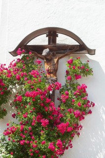Crucifix with roses at the church of St. Ägidius and Nikolaus, Grainbach, Samerberg, Chiemgau,