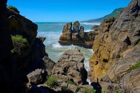 Coastline with steep cliffs and dense vegetation in the distance, Pancake Rocks, Westport,