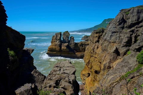 Rocky cliffs overlooking the sea under a clear blue sky, Pancake Rocks, Westport, Greymouth, West