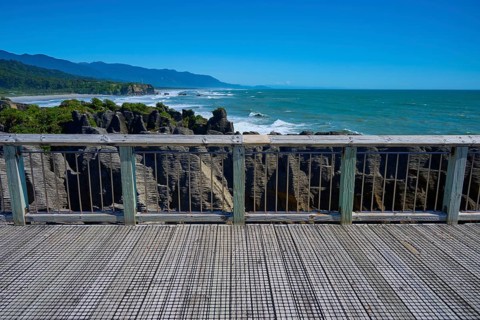 View from a platform with wooden railings of the rugged coastal rocks and the sea, Pancake Rocks,
