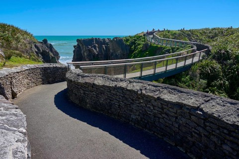 Extensive stone paths lead over a bridge past cliffs overlooking the sea, Pancake Rocks, Westport,