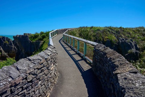 A stone path leads along the cliffs with a picturesque view of the sea, Pancake Rocks, Westport,