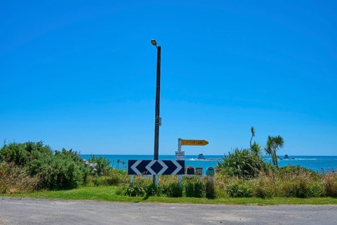 View of a coastline with road signs and blue sky, Cape Foulwind, West Coast, South Island, New