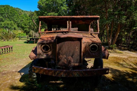 Abandoned, rusty lorry standing in the forest in rustic surroundings, Buller Gorge Swing Bridge,