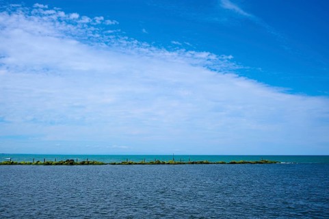 Sweeping view of the calm sea under a partly cloudy blue sky, Mana Bay, Patea, Taranaki, North