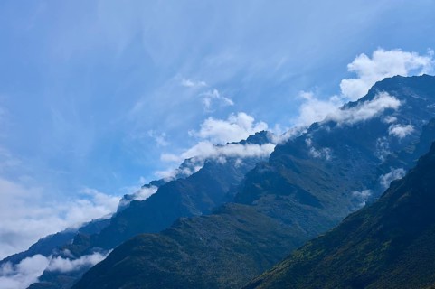 Mountain peak in the foreground with white clouds in the sky, Drift Bay, Lake Wakatipu,