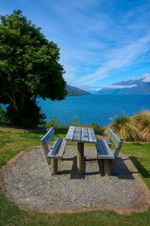 Single picnic table overlooking lake and mountains in scenic setting, Drift Bay, Lake Wakatipu,