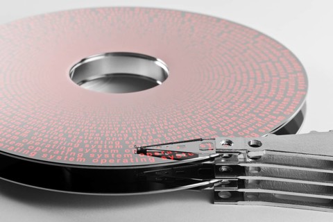 Detail shot of a separated hard disk platter with actuator arm in light grey backAllegory theme
