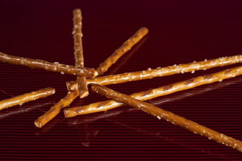 Closeup of some salt sticks on dark red striped glossy ground