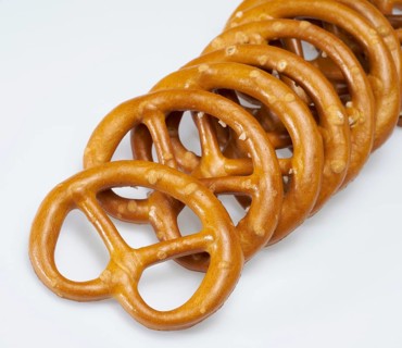 Some lye pretzels in a row in light back