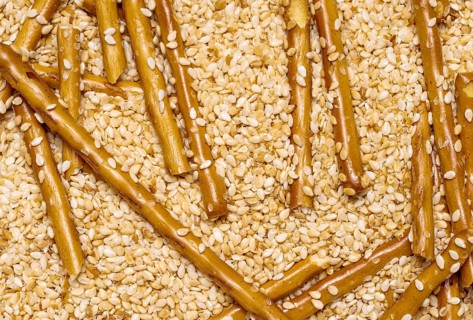 Full frame closeup of some baked sesame sticks in sesame back