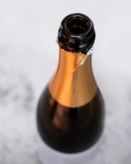 Open champagne bottle seen from above in light ambiance