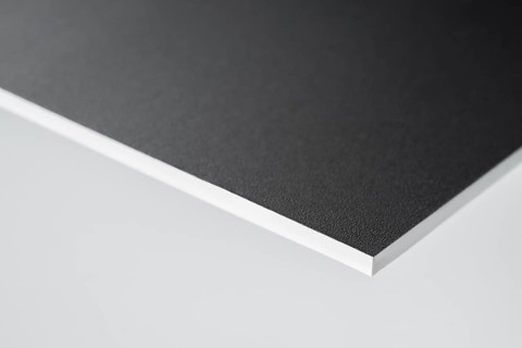 Edge of a black covered white board in light grey back