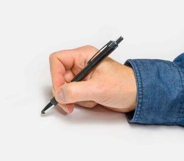 Male hand with ball pen in light back