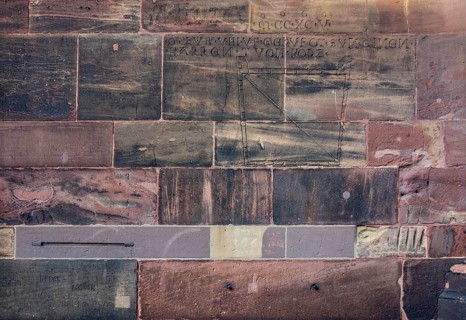 Historic engravings on a stone wall at the Freiburg Minster in Freiburg im Breisgau, a city in