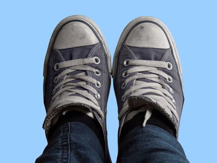 Some feet with sneakers in front of blue sky