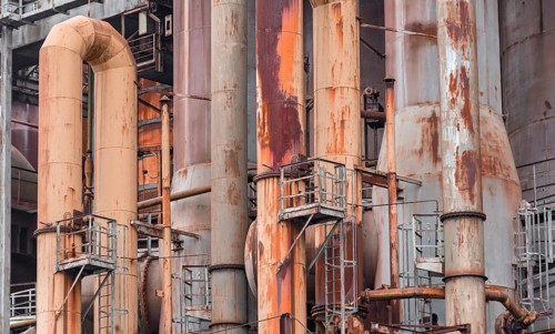 Weathered rusty industrial scenery with old corroded steel girders and metal tubes