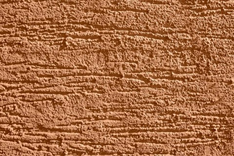 Full frame background showing brown rough plaster