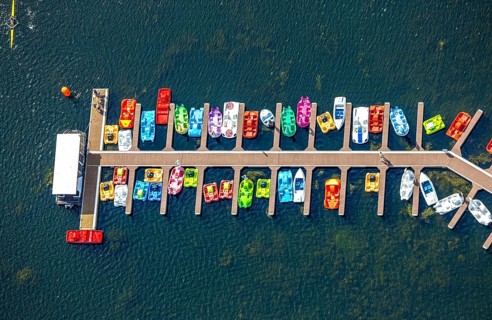 Aerial view, colourful pedal boats at a jetty on the Unterbacher See at the campsite north,