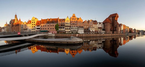 Panorama of the waterfront promenade with reflection at sunrise in the Old Town, Motlawa River,