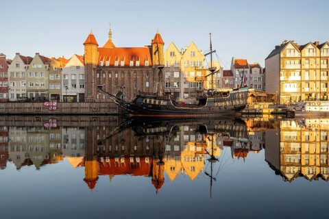 Waterfront promenade with reflection at sunrise in the Old Town, pirate ship, excursion boat,