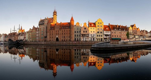Panorama of the waterfront promenade with reflection at sunrise in the Old Town, Motlawa River,