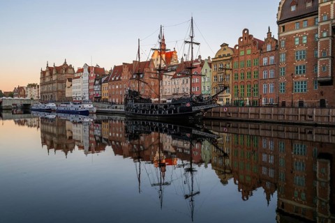 Waterfront promenade with reflection at sunrise in the Old Town, pirate ship, excursion boat,