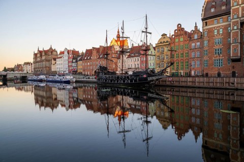 Waterfront promenade with reflection at sunrise in the Old Town, pirate ship, excursion boat,