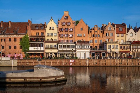 Waterfront promenade with reflection at sunrise in the Old Town, Motlawa River, Gdansk, Poland