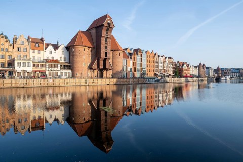 Waterfront promenade with reflection at sunrise in the Old Town, Motlawa River, Gdansk, Poland