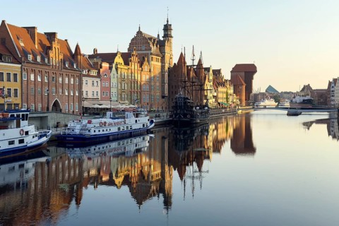 Waterfront promenade with reflection at sunrise in the Old Town, Motlawa River, Gdansk, Poland