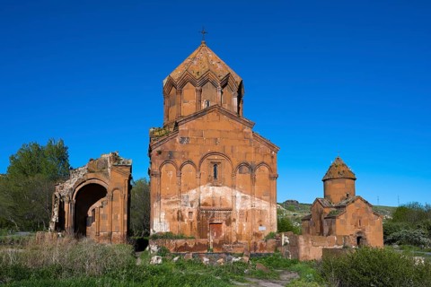 Historic brick church under a clear sky, surrounded by vegetation, cross-domed church, Marmashen