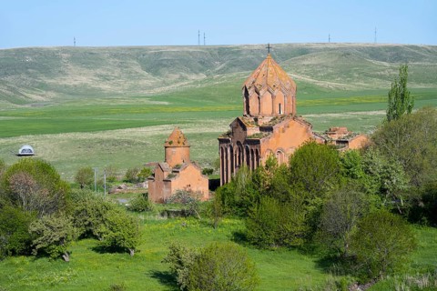 Historic church in the middle of a green landscape with hills and clear skies, Marmashen Monastery,