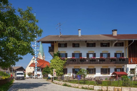 Parish Church of the Assumption of the Virgin Mary with maypole and old houses on the village