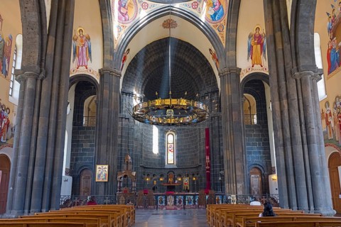 Magnificent church interior with stained glass windows, works of art and a radiant altar area,