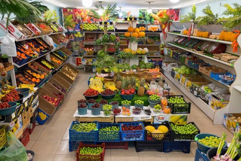 A well-stocked shop full of colourful fruit and vegetables displayed on shelves and tables, Gyumri,