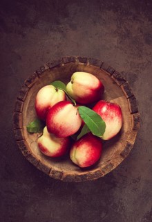 Ripe nectarine, in a wooden plate, brown background, top view, no people