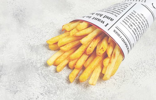 Fried French fries in a paper bag, on an abstract background, without people, in a rustic style, in