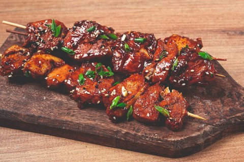 Yakitori chicken kebab, on skewers, with green onions and sesame seeds, top view, without people